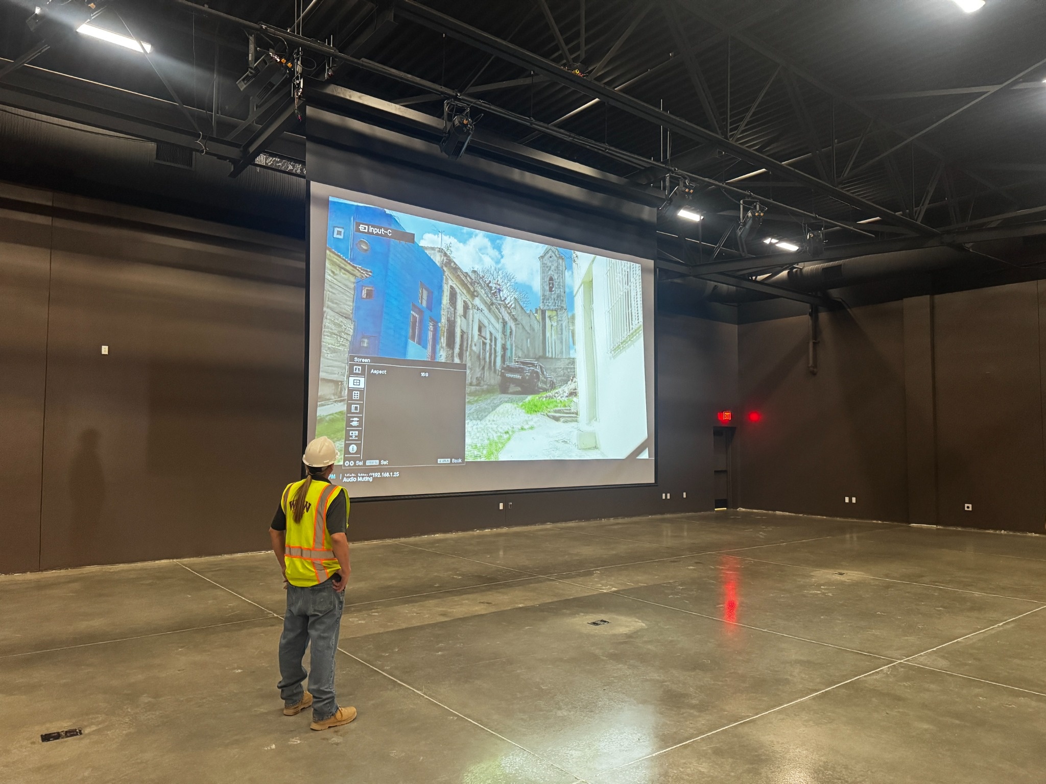 Technician commissioning the 220-inch motorized screen and Sony laser projector in the Cocopah Event Center